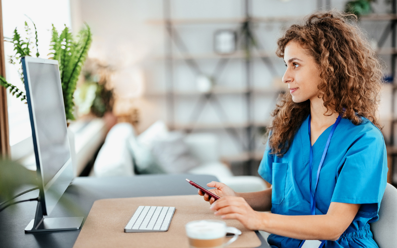 zorgprofessional aan bureau met desktop en telefoon