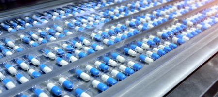 Blauw/witte capsules op een lopende band
